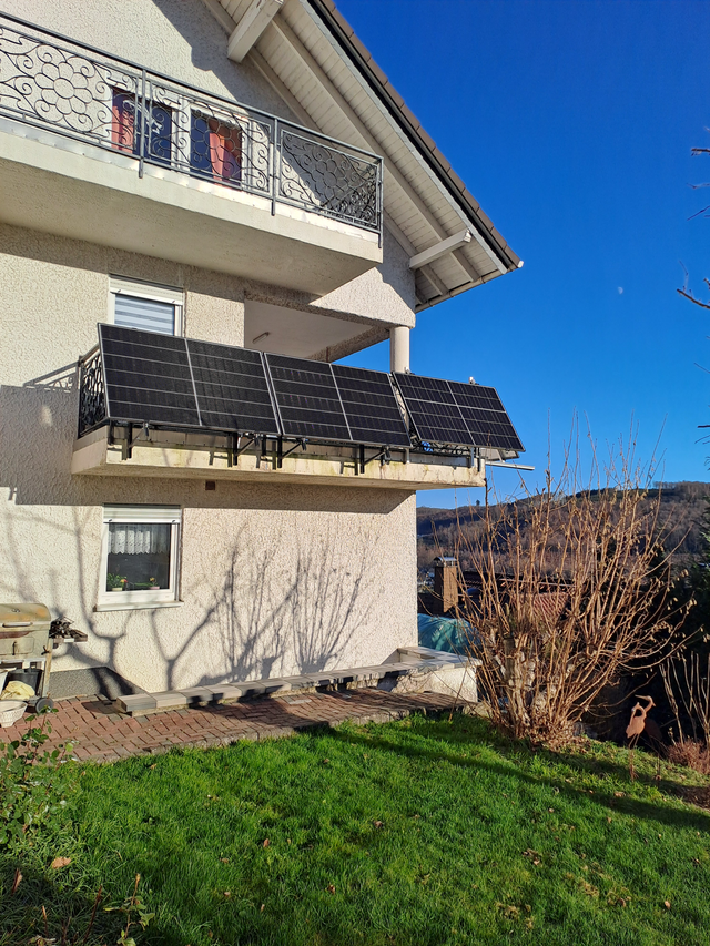 Vier Solarmodule an einem Balkon eines Wohnhauses