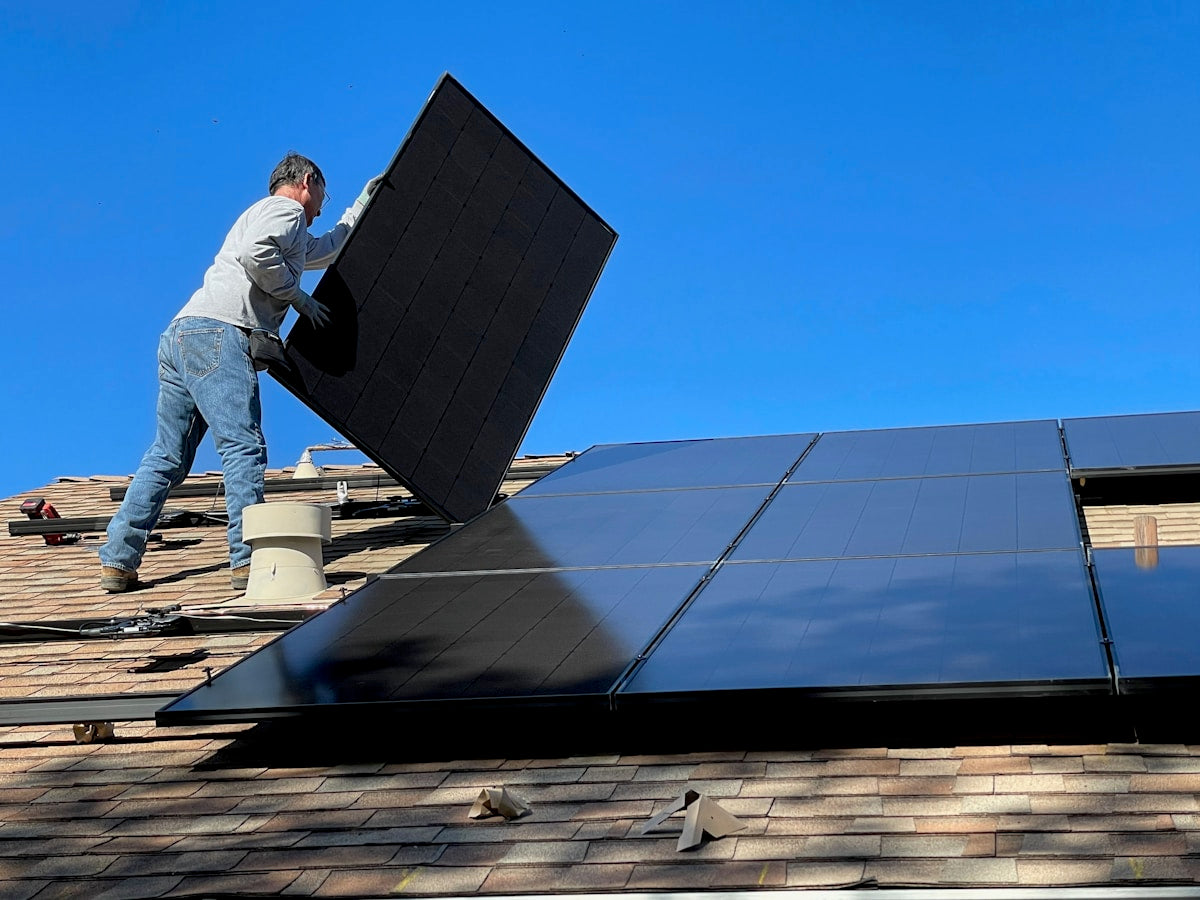 Solartechniker montiert Photovoltaikmodule auf einem Hausdach